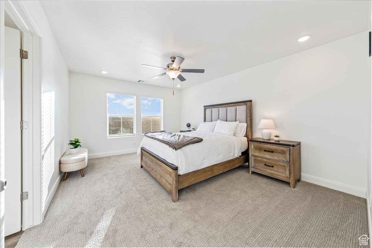 Bedroom featuring light carpet, recessed lighting, a ceiling fan, and baseboards