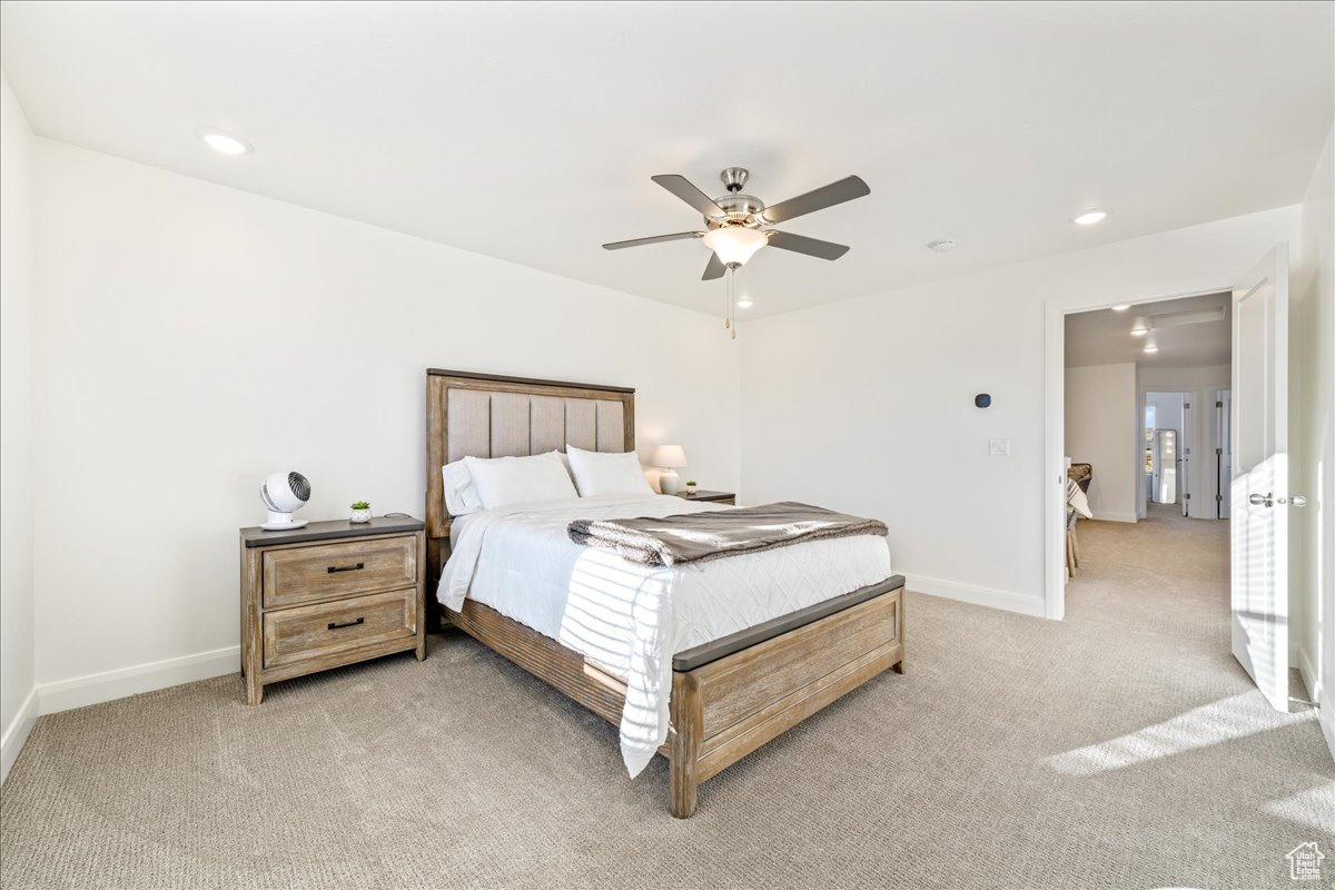 Bedroom with recessed lighting, light colored carpet, a ceiling fan, and baseboards