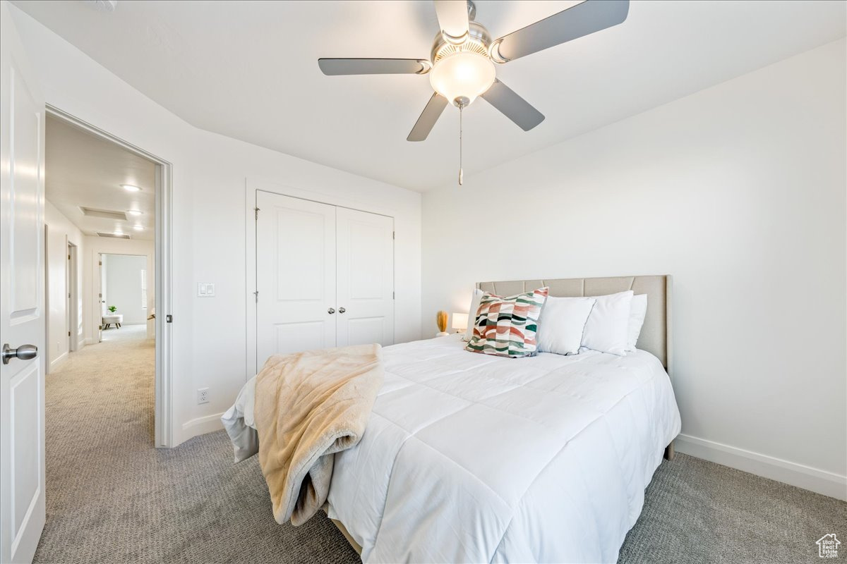 Bedroom featuring a closet, ceiling fan, baseboards, and carpet floors