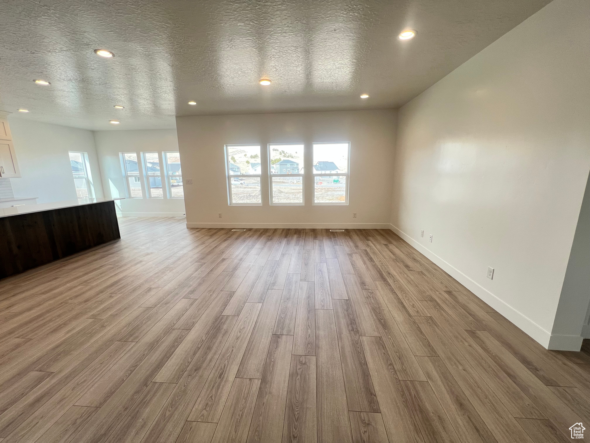 Unfurnished living room featuring recessed lighting, a textured ceiling, and light wood finished floors