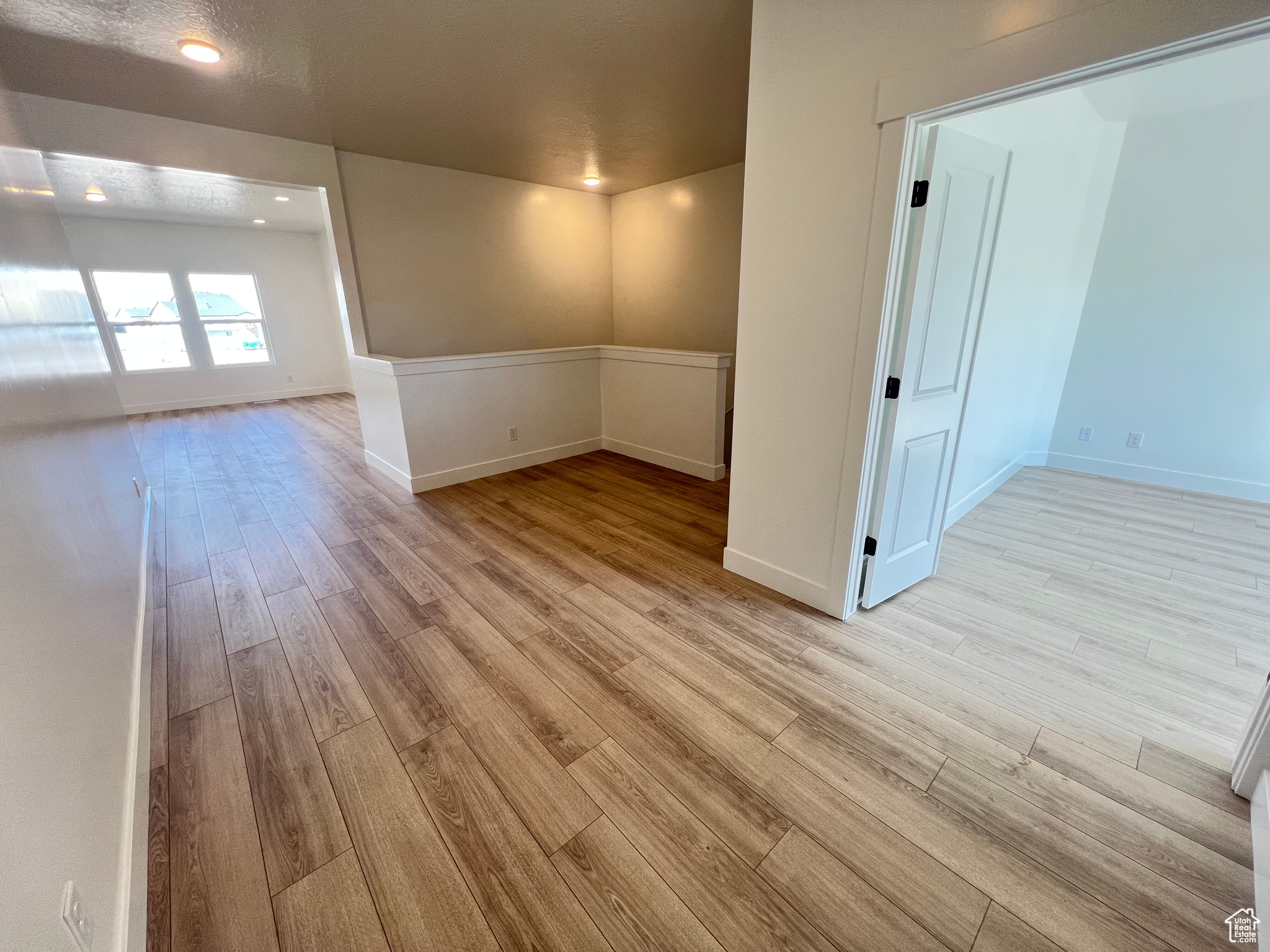 Spare room with recessed lighting, baseboards, and light wood finished floors