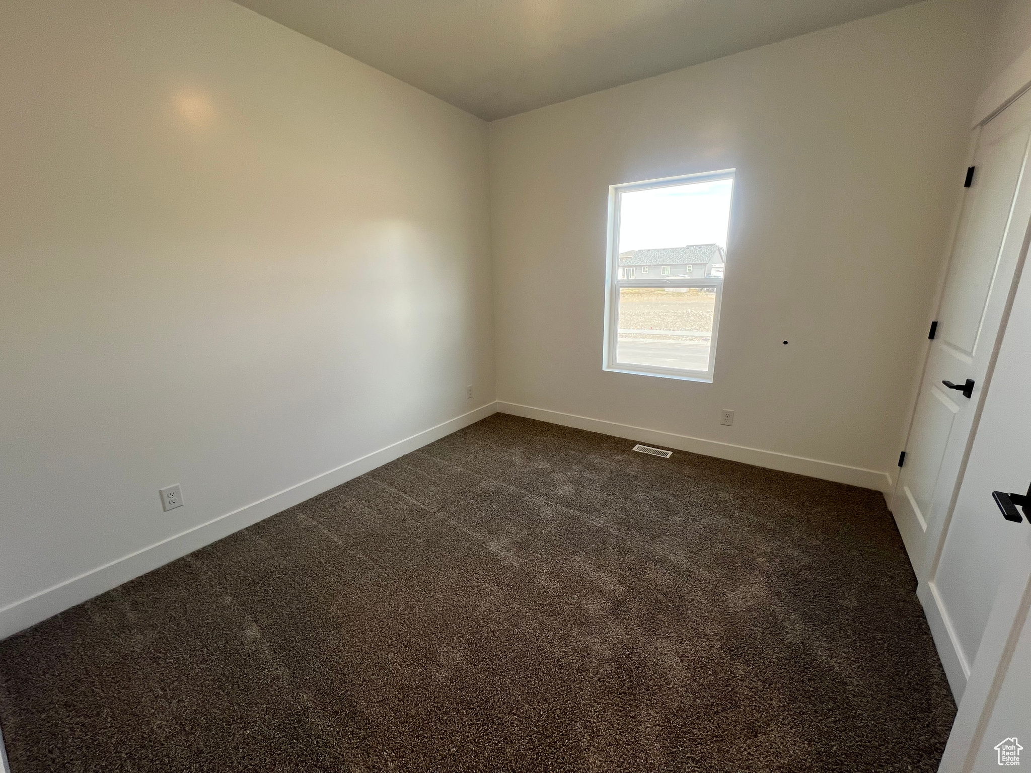 Unfurnished bedroom featuring baseboards and dark carpet