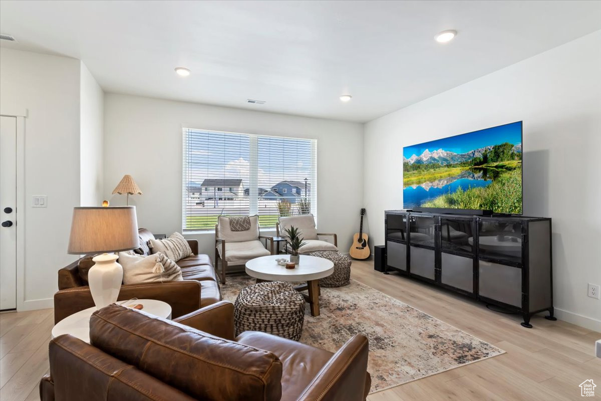 Living area featuring visible vents, recessed lighting, baseboards, and light wood-type flooring