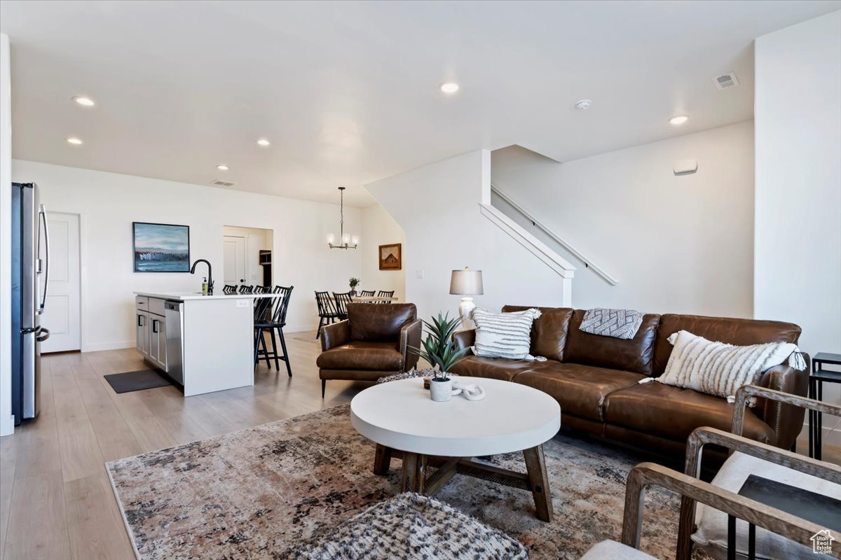 Living room featuring an inviting chandelier, recessed lighting, visible vents, and light wood finished floors