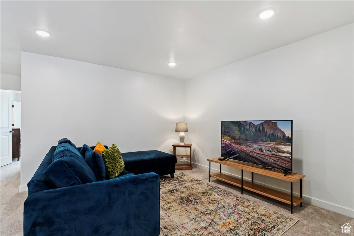 Living area with recessed lighting, baseboards, and carpet floors