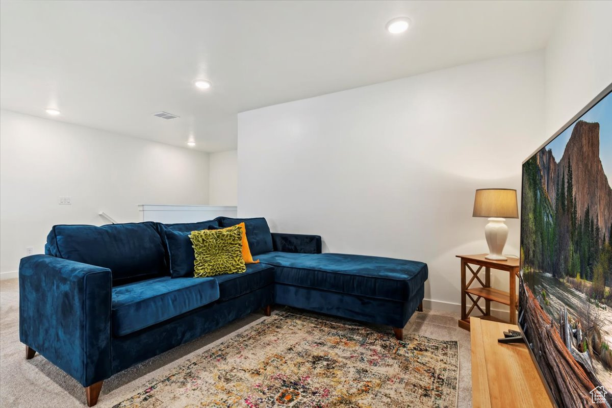 Living area with recessed lighting, visible vents, and baseboards