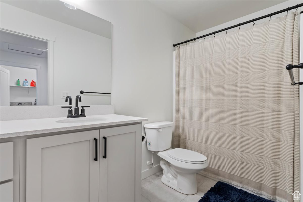 Bathroom with vanity, toilet, and a shower with curtain