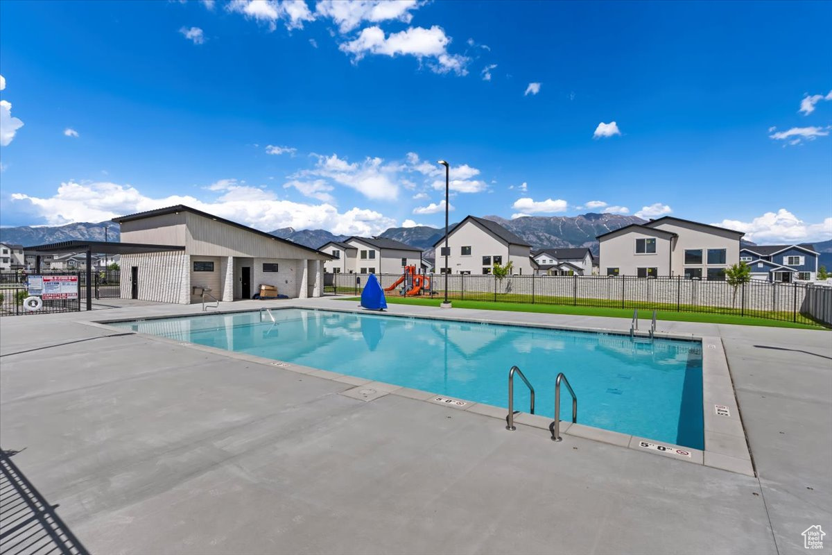 Pool featuring a mountain view, a residential view, and fence