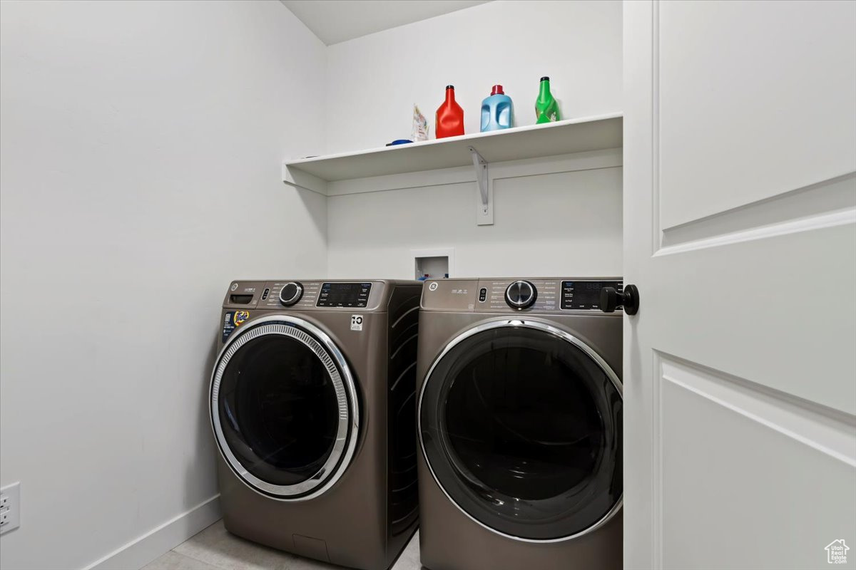 Clothes washing area featuring washer and dryer, baseboards, and laundry area