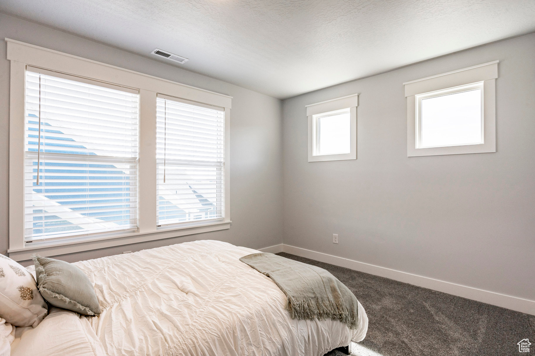 Bedroom featuring visible vents, baseboards, carpet, and a textured ceiling