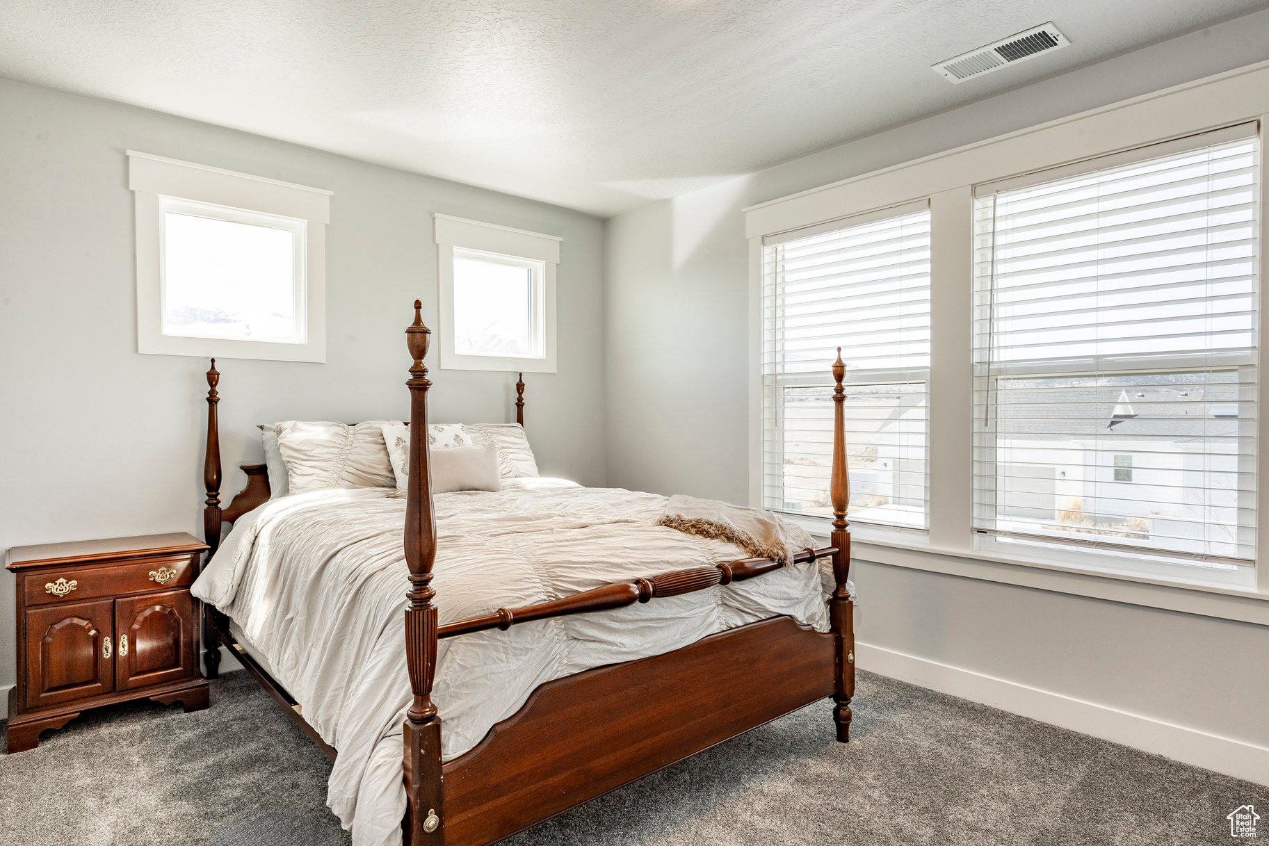 Bedroom with visible vents, baseboards, and dark colored carpet