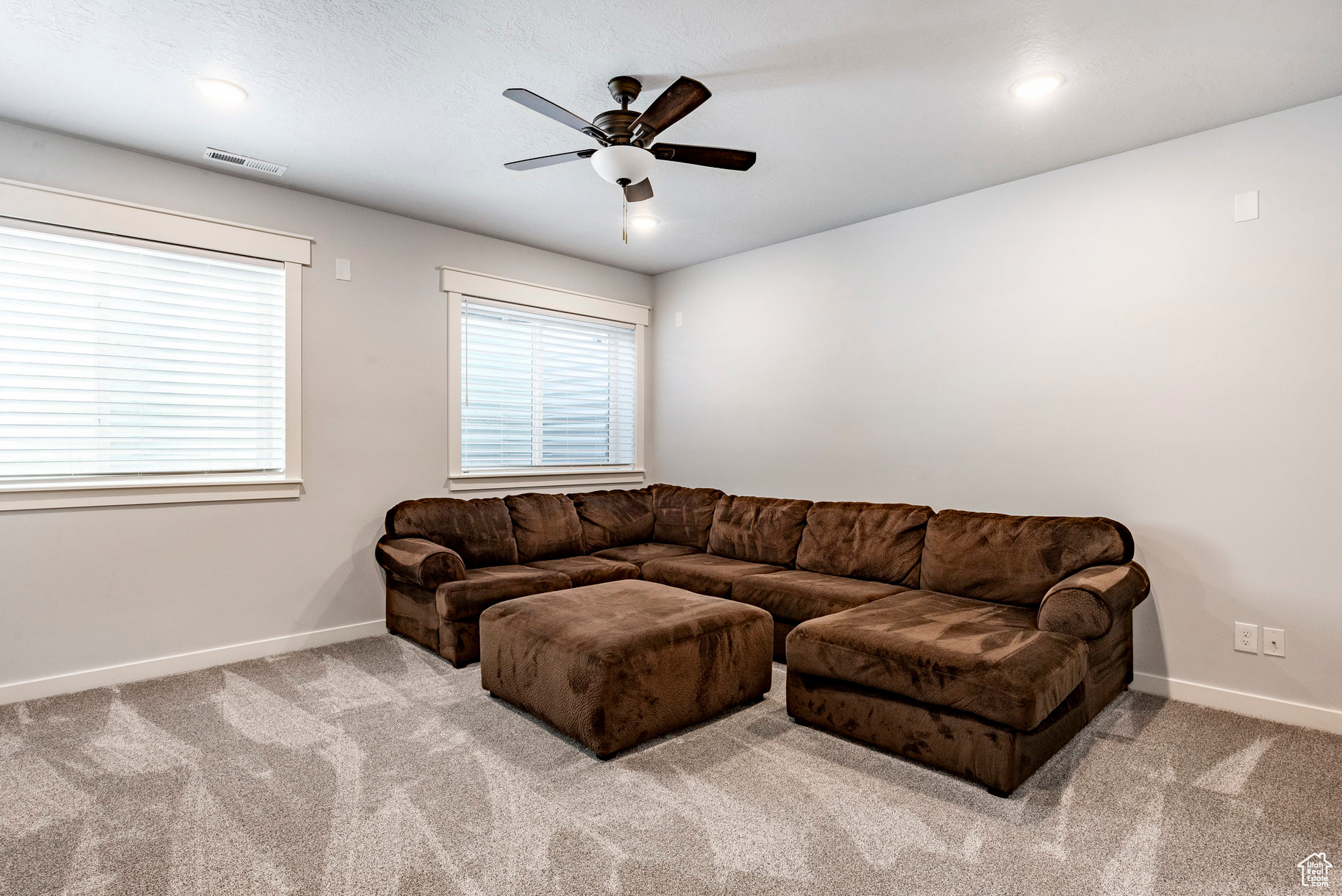 Living area featuring visible vents, baseboards, carpet, and ceiling fan