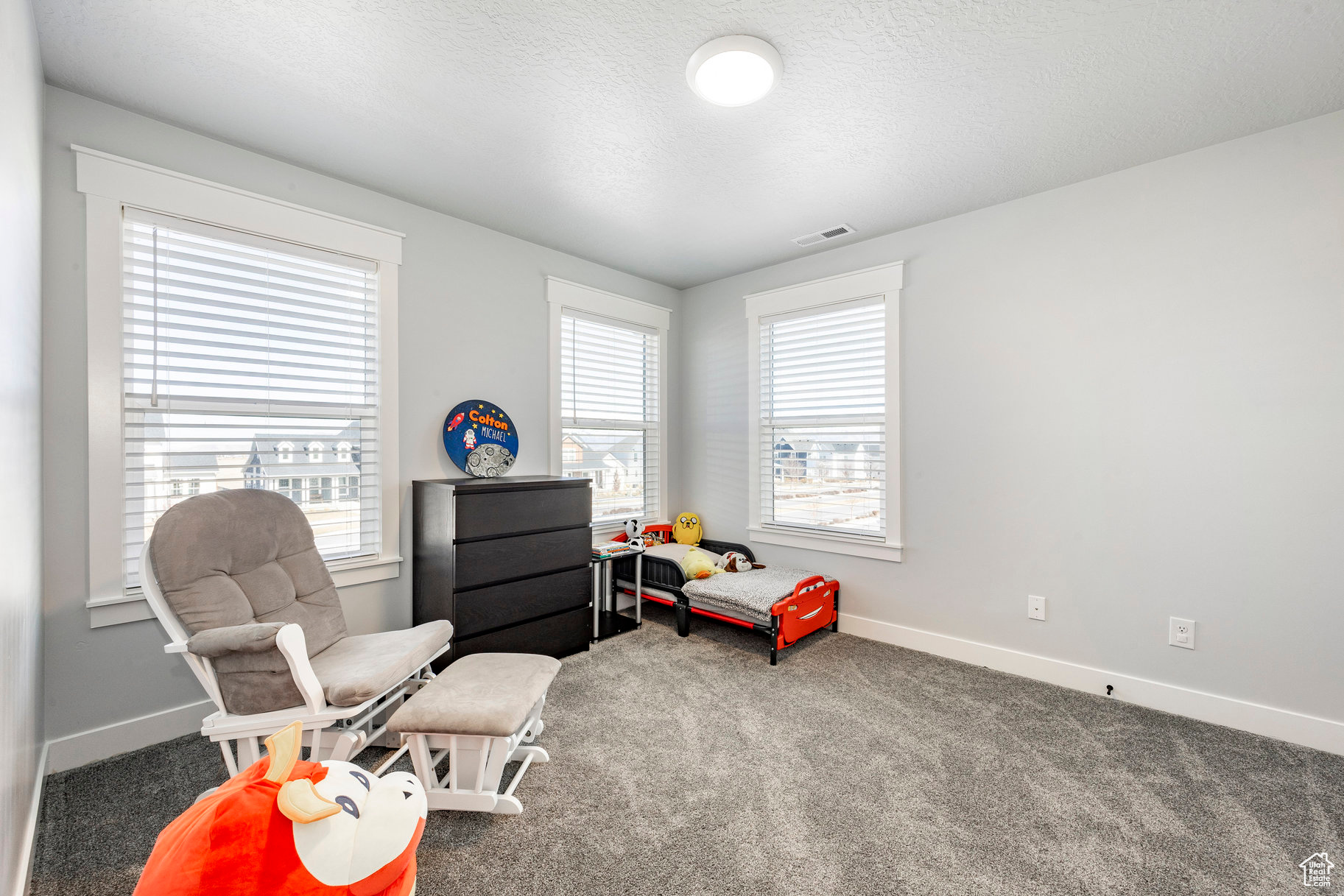 Sitting room featuring visible vents, baseboards, a textured ceiling, and carpet flooring
