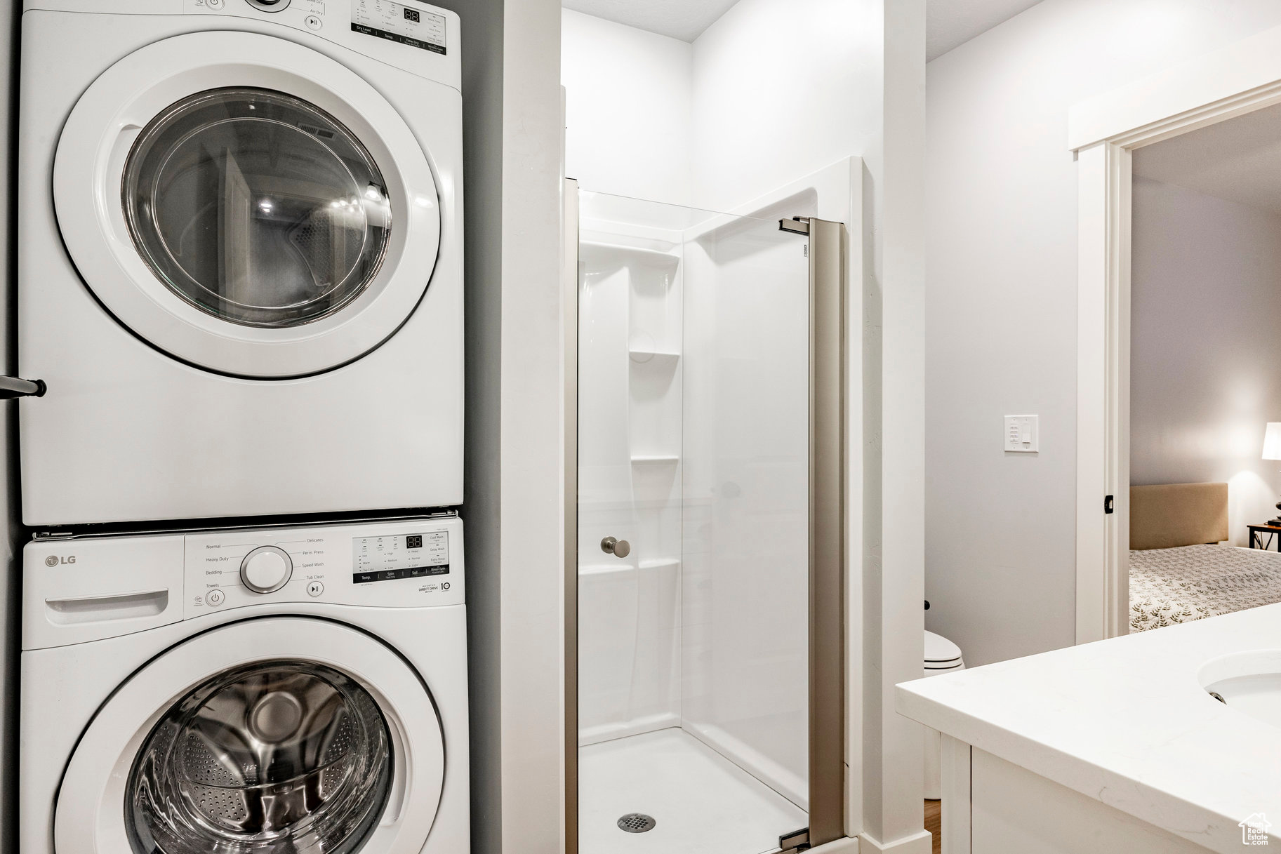Clothes washing area featuring laundry area and stacked washer and clothes dryer