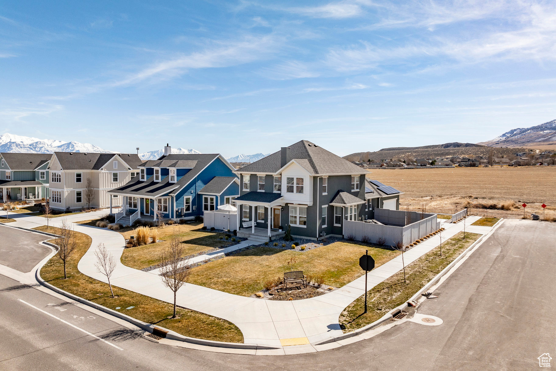 View of front of home with a mountain view, a residential view, a front lawn, and fence
