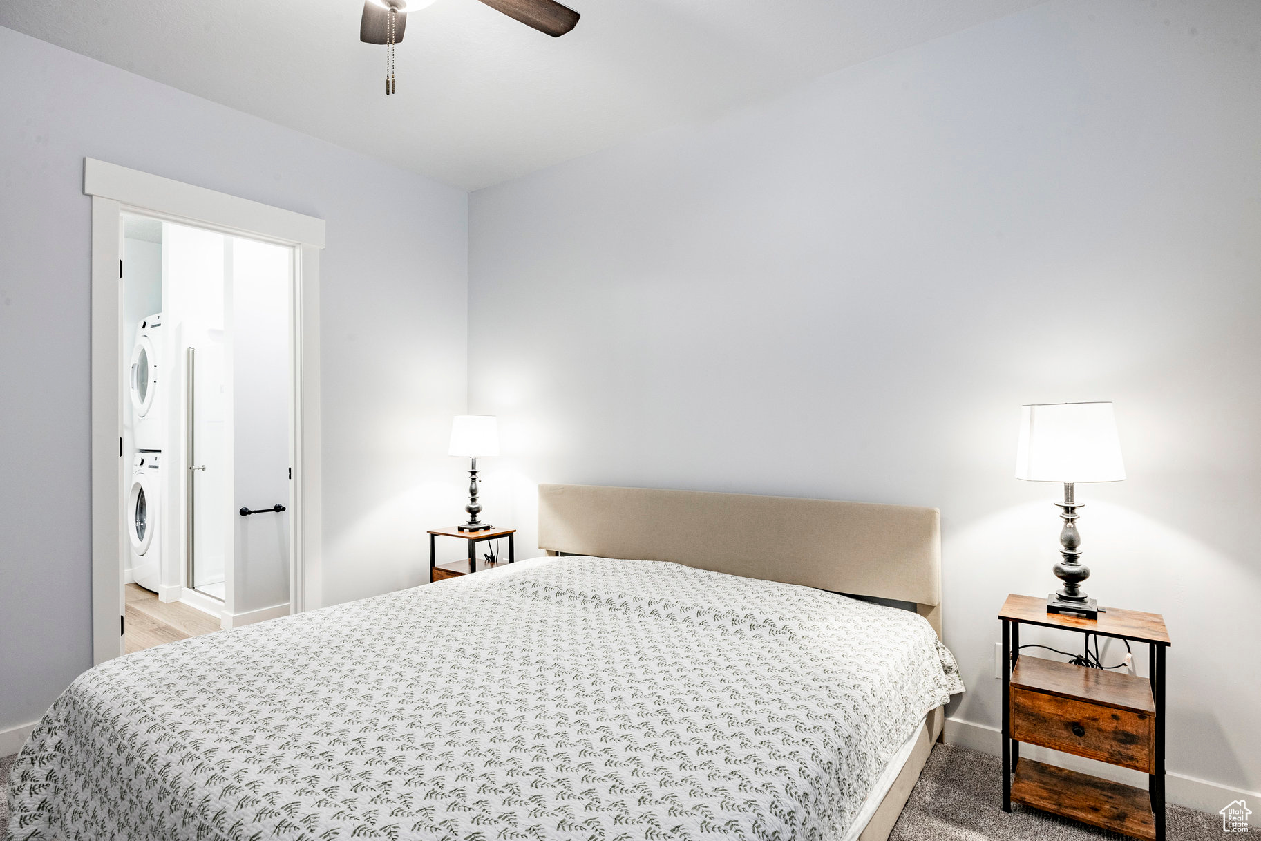 Bedroom featuring stacked washer and dryer and baseboards
