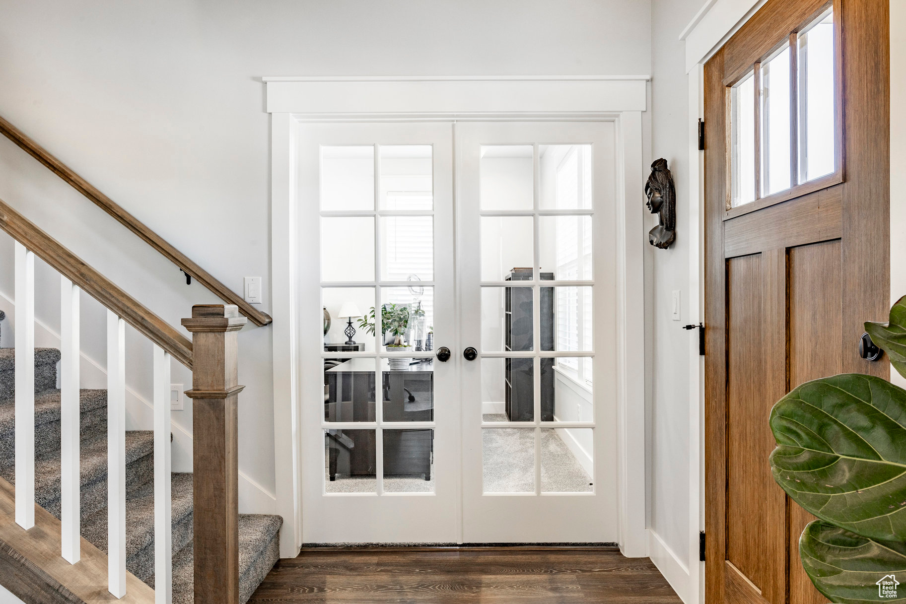 Entrance foyer with french doors, stairs, and dark wood-style flooring