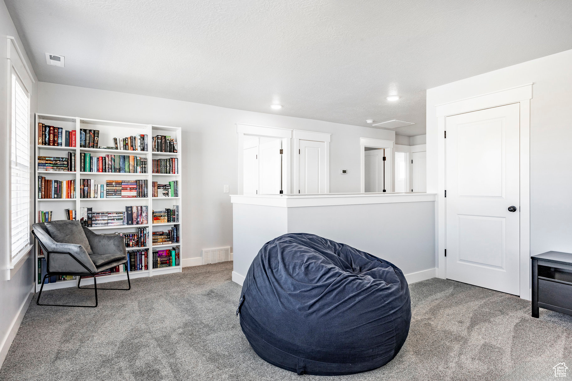 Living area with visible vents, carpet floors, and baseboards