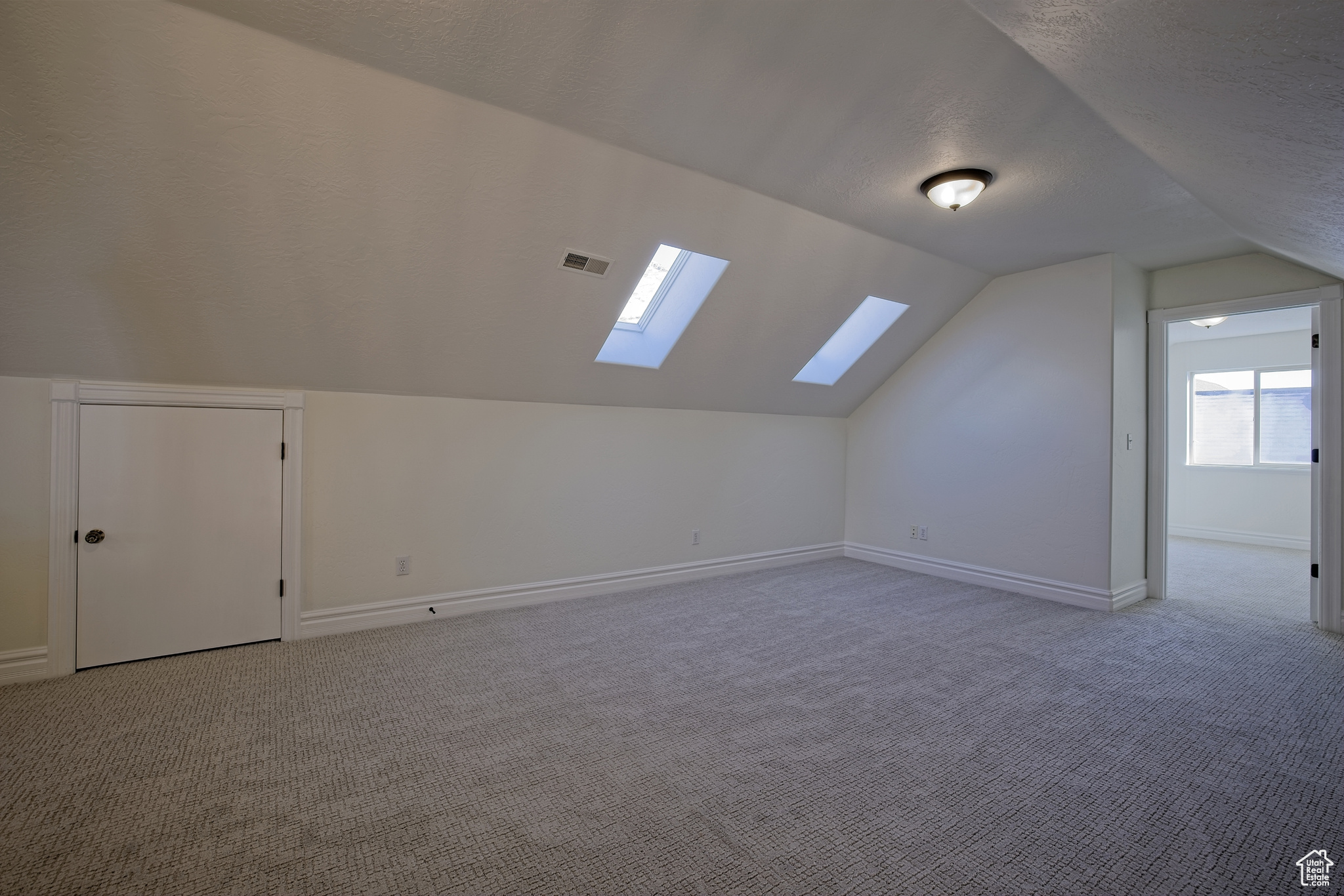Bonus room with skylights by bedrooms with brand new carpet