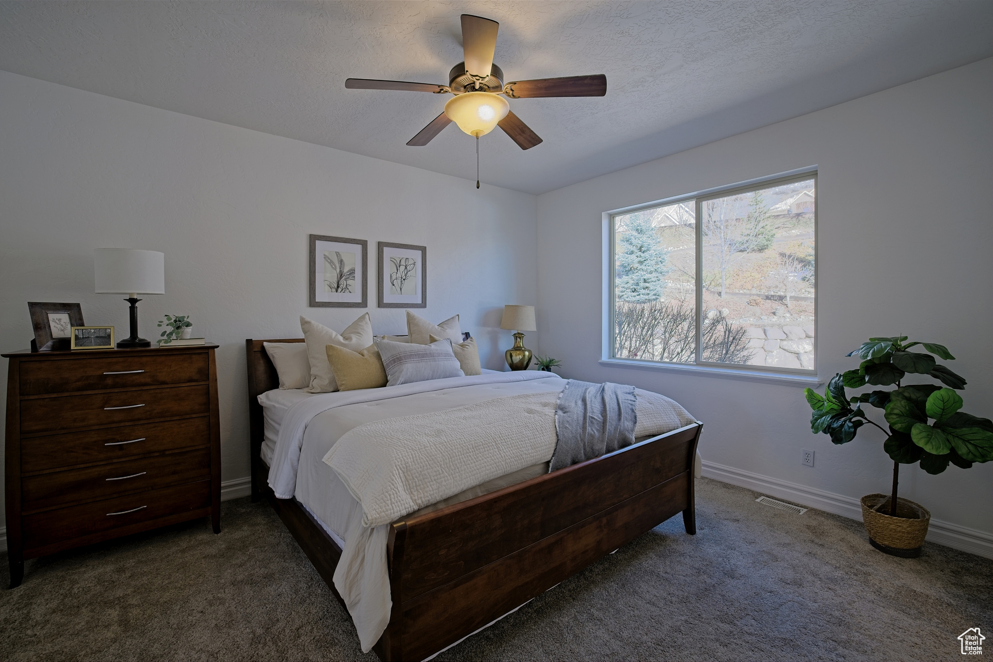Carpeted bedroom with ceiling fan and private mountain views