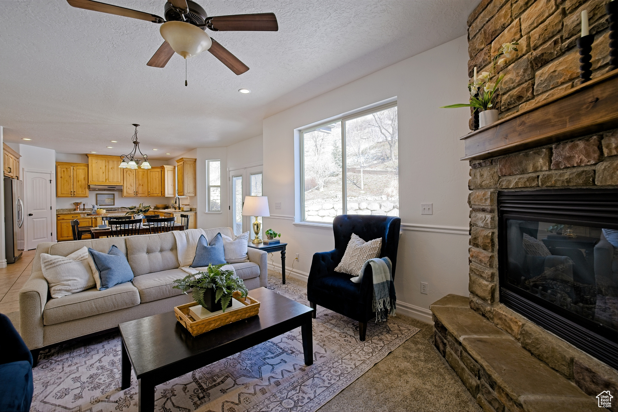Living area with a ceiling fan, recessed lighting, a fireplace, and light colored carpet