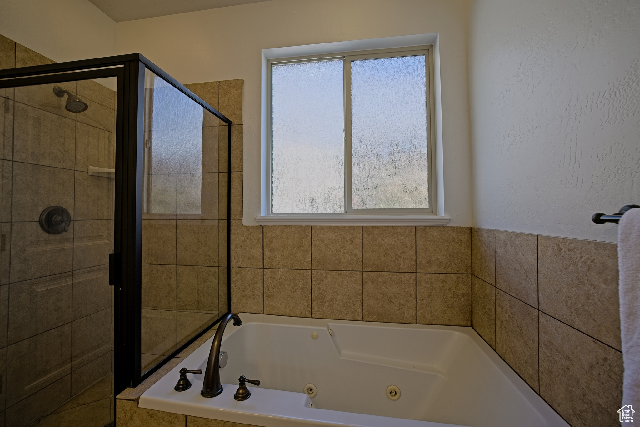 Bathroom with a shower stall and a jetted tub