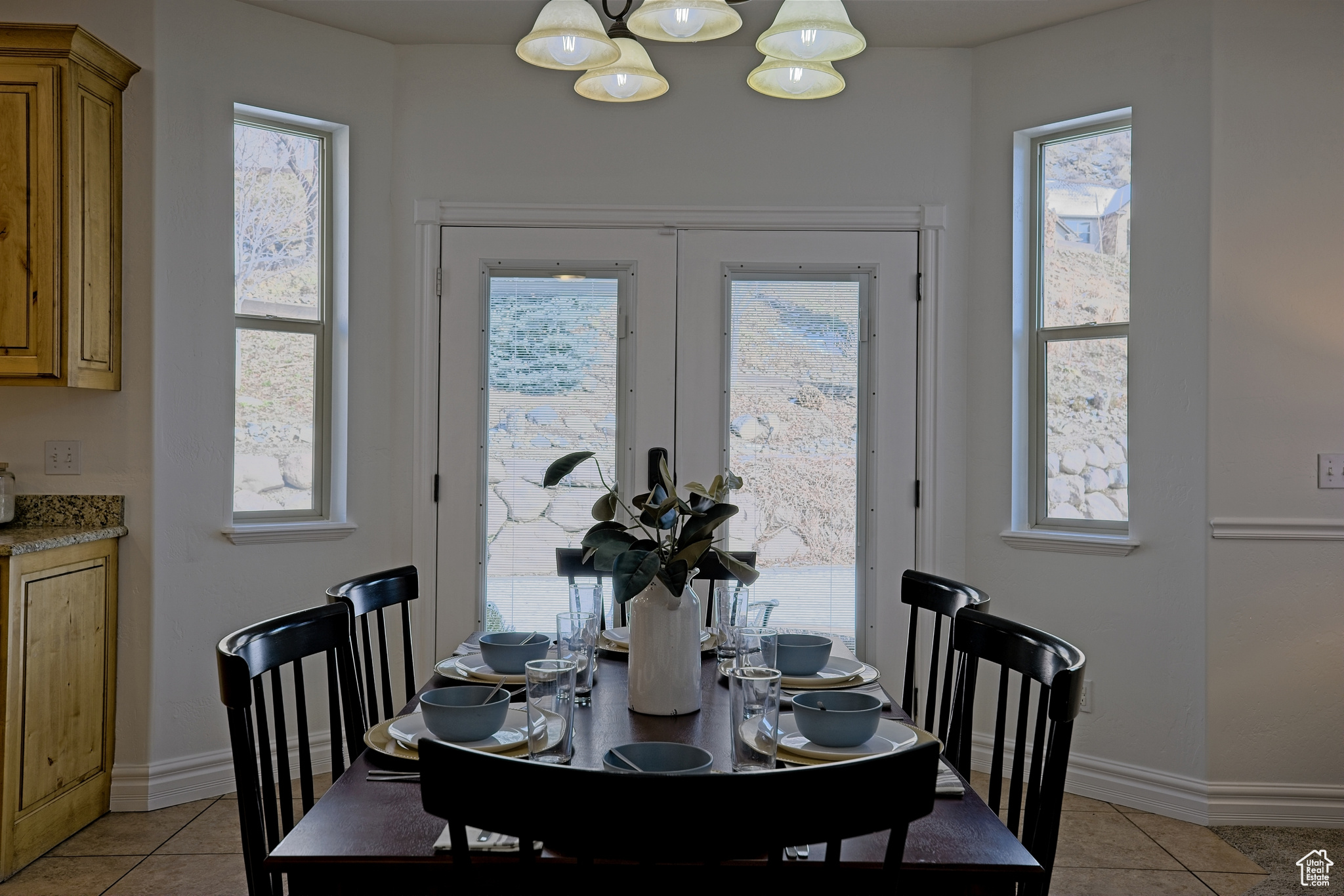 Dining area featuring light tile patterned floors, and a notable chandelier