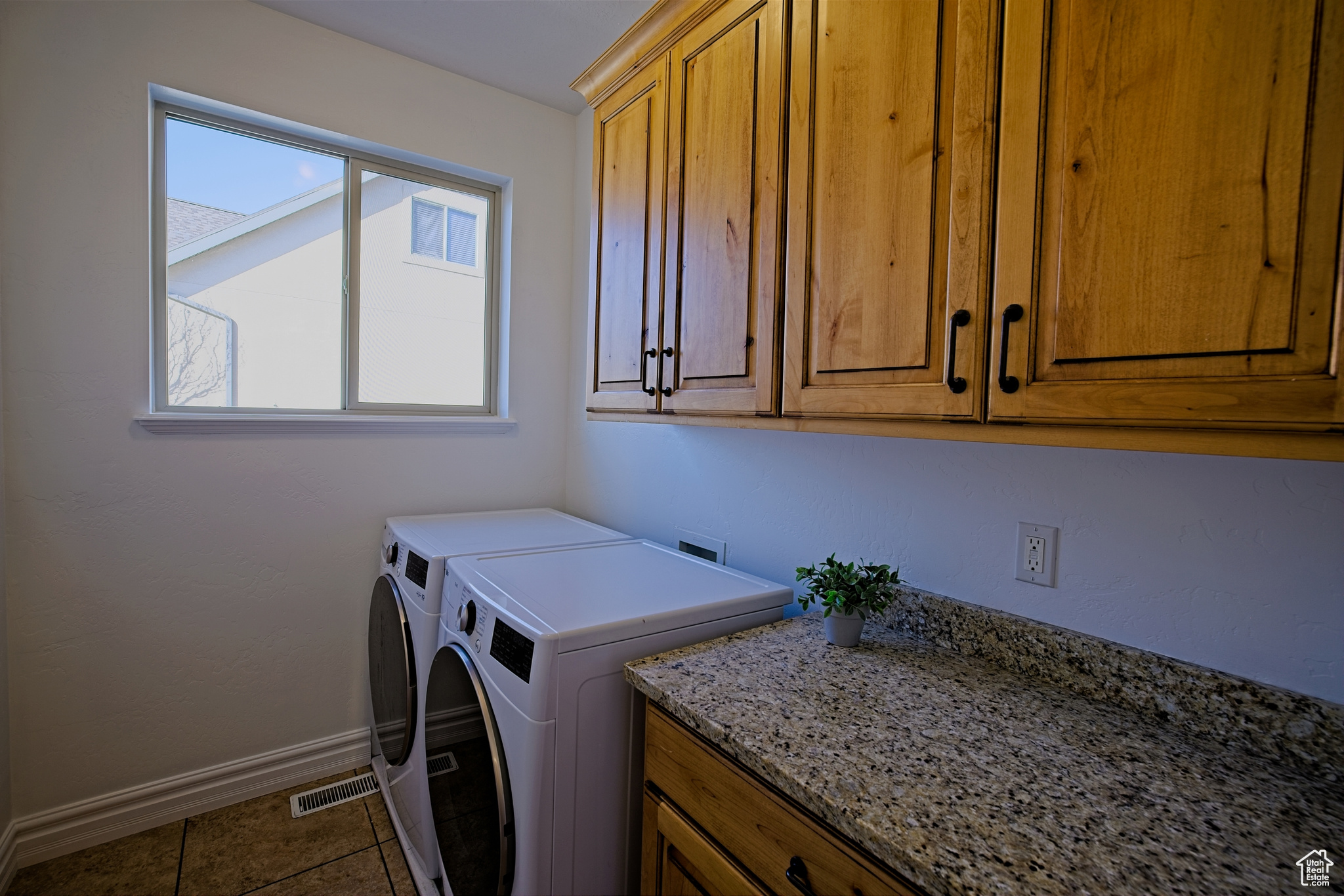 Washroom featuring dark tile patterned flooring and cabinet space