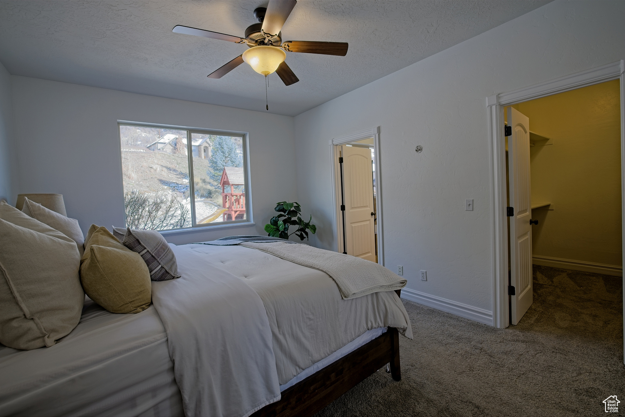 Bedroom with a walk in closet, bathroom, ceiling fan and private mountain views