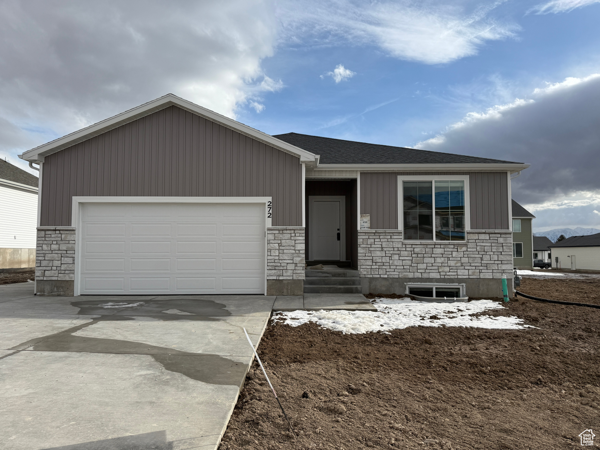 Ranch-style house featuring an attached garage, stone siding, driveway, and a shingled roof