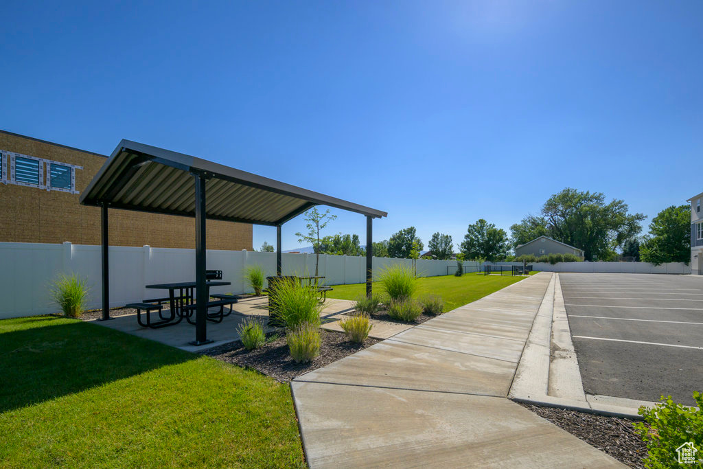 View of property's community featuring a patio area, a lawn, and a fenced backyard