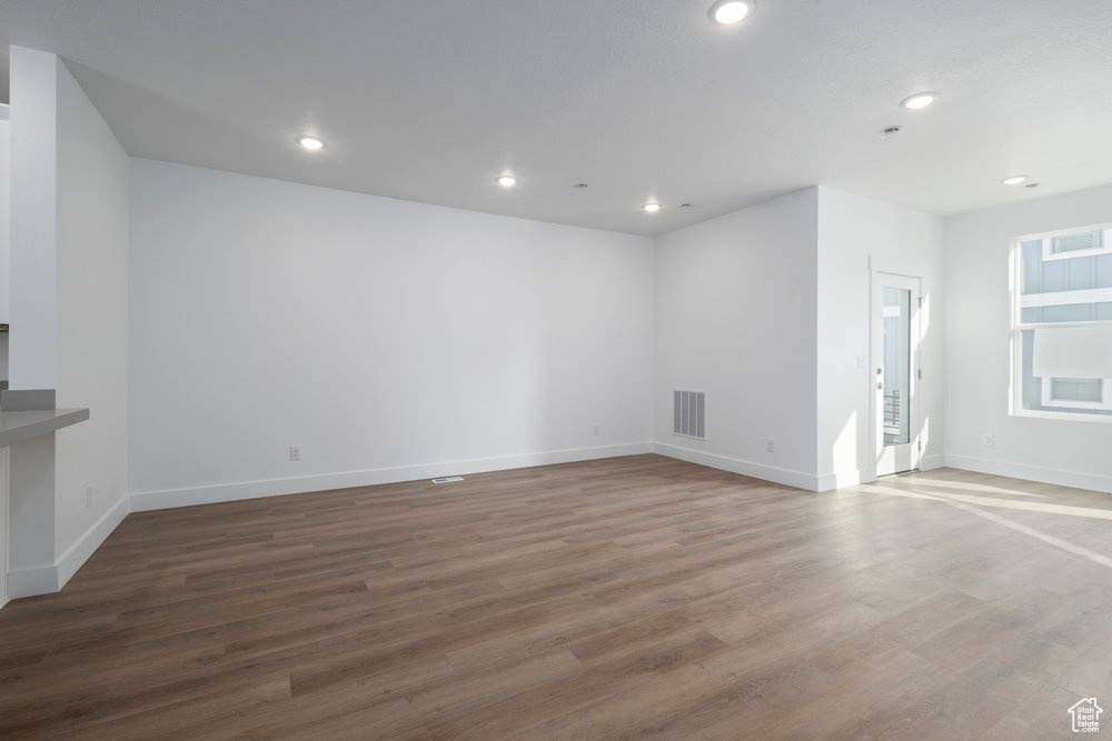 Unfurnished living room with visible vents, recessed lighting, and wood finished floors