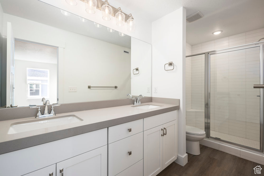 Bathroom with a stall shower, wood finished floors, and a sink