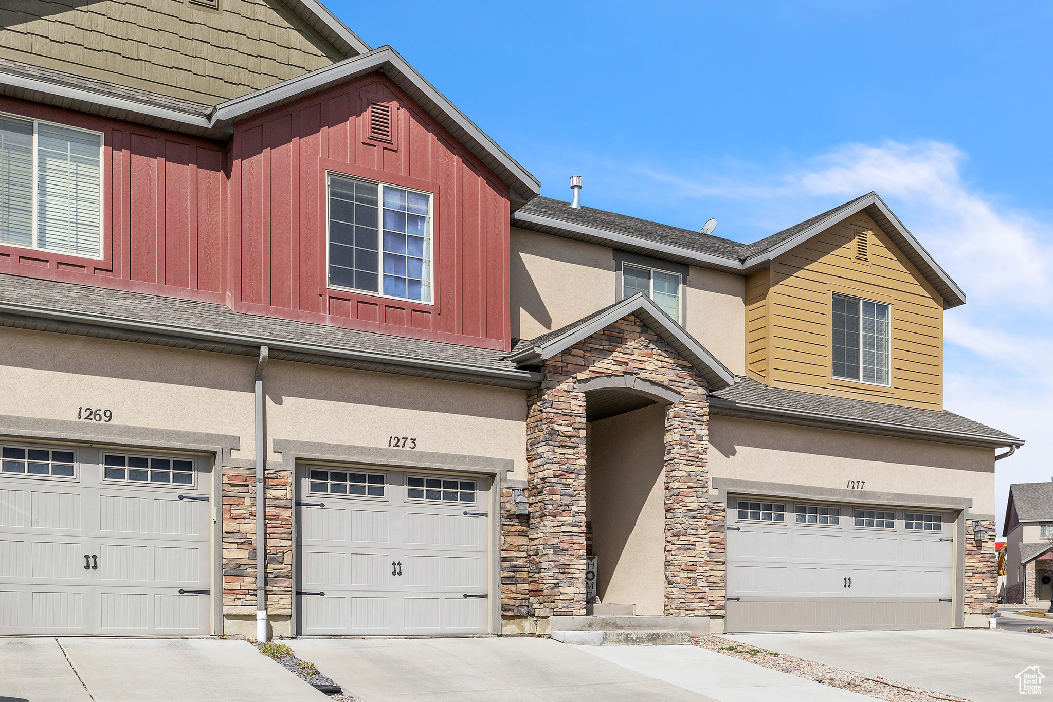 View of front facade featuring board and batten siding, an attached garage, and concrete driveway