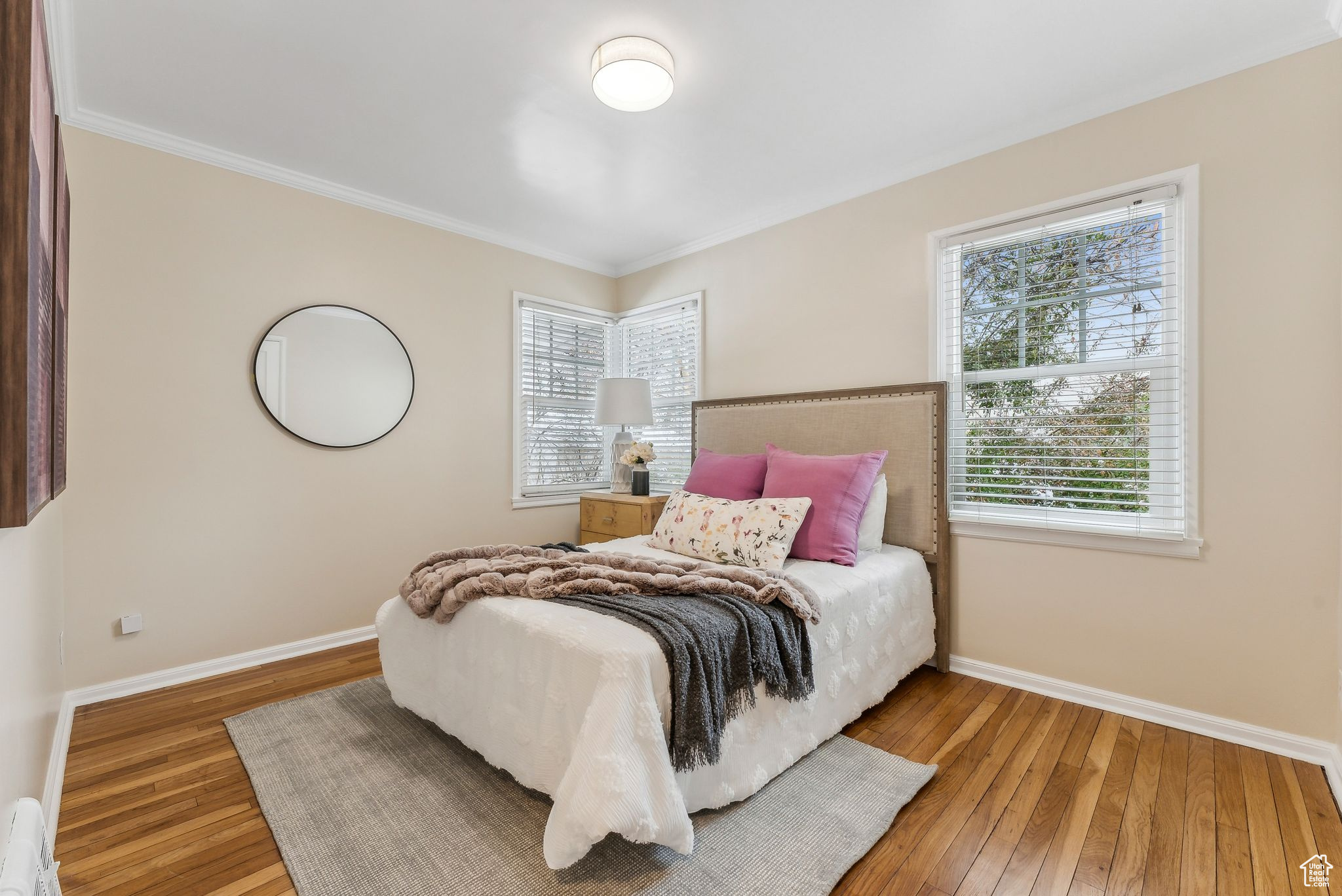 Bedroom featuring baseboards, wood-type flooring, and ornamental molding