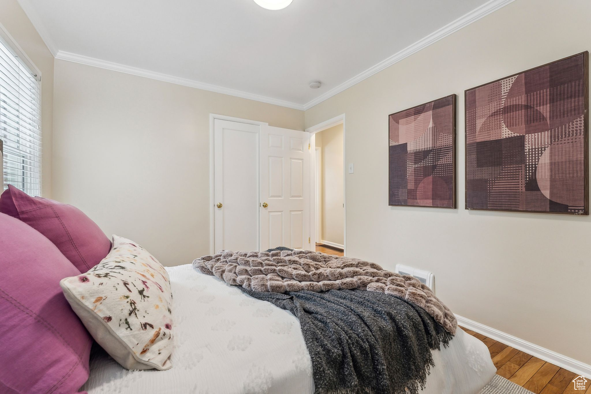 Bedroom featuring baseboards, wood finished floors, and crown molding