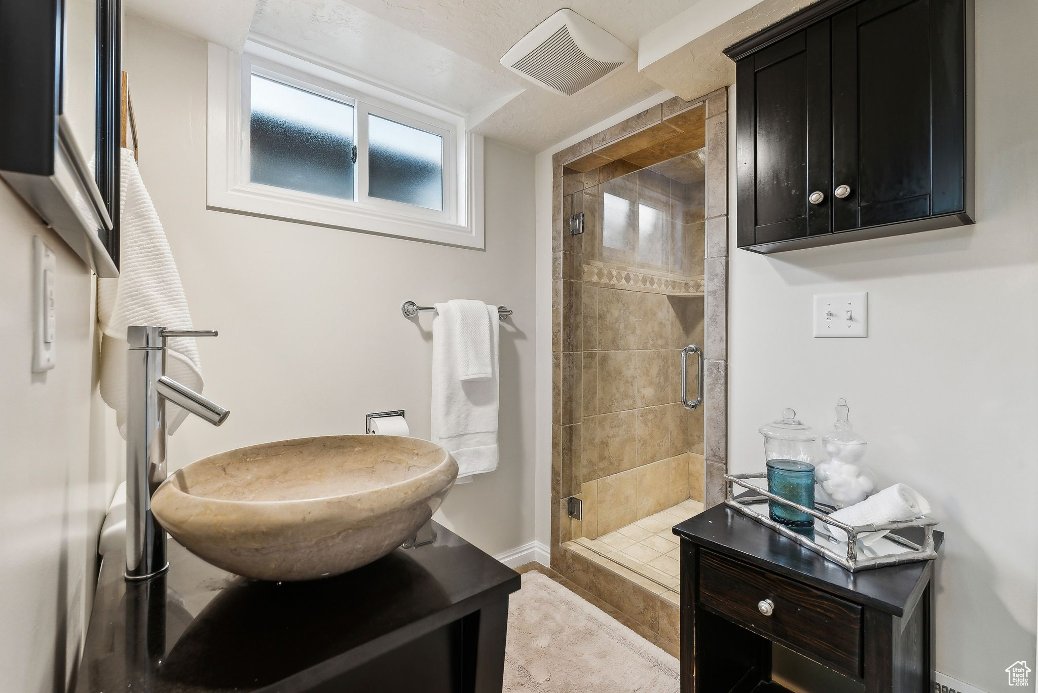 Bathroom featuring vanity, a shower stall, baseboards, and visible vents