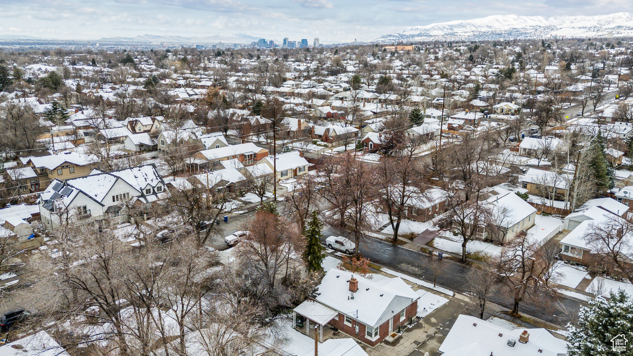 Snowy aerial view featuring a mountain view and a residential view