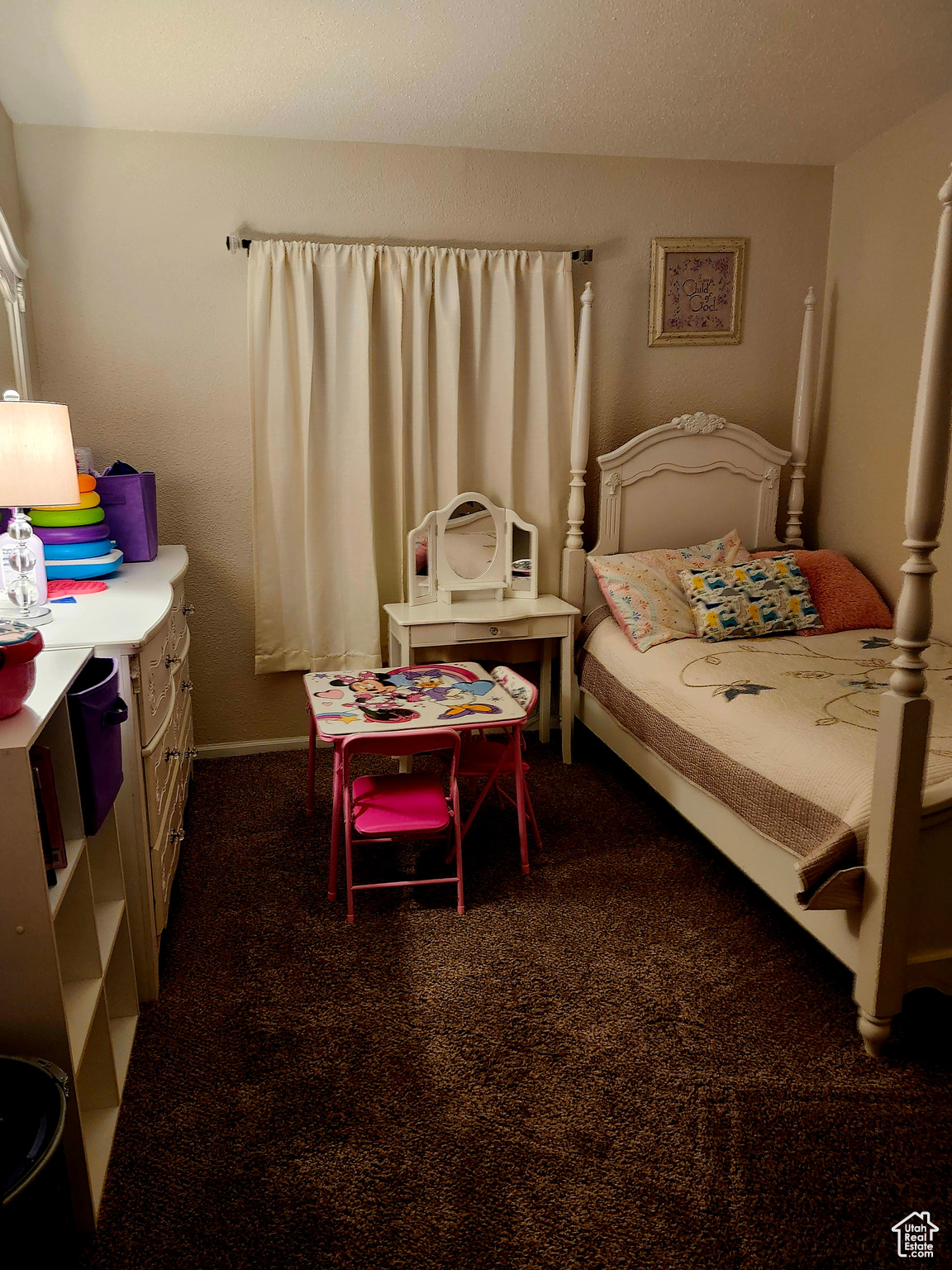 Bedroom featuring baseboards and dark carpet