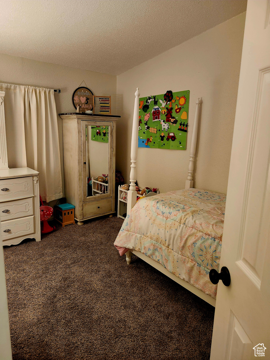 Bedroom featuring dark carpet and a textured ceiling