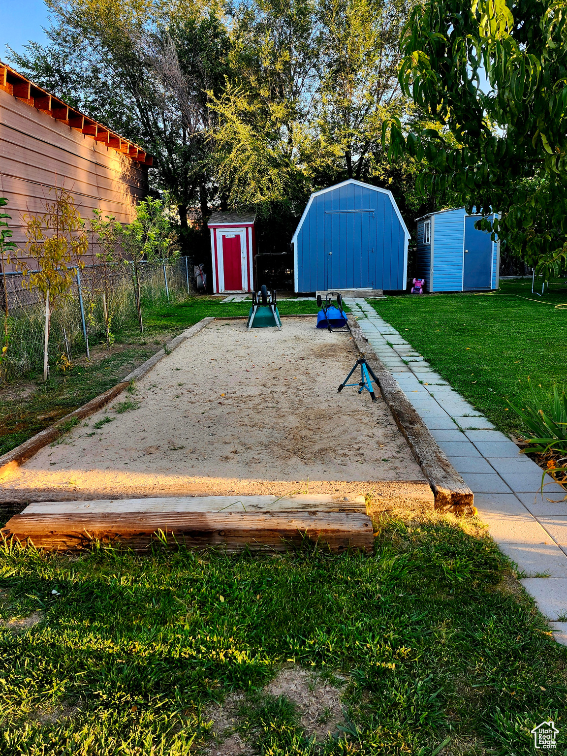 View of yard featuring an outdoor structure, a storage unit, and fence