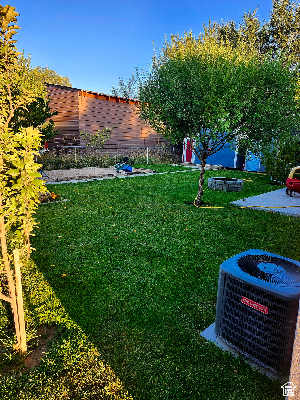 View of yard featuring cooling unit and fence