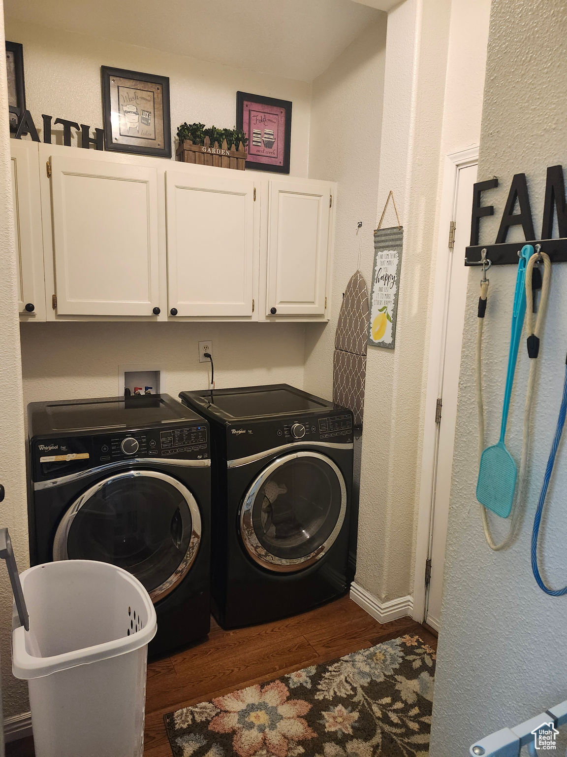 Laundry room with washer and dryer, dark wood-type flooring, and cabinet space