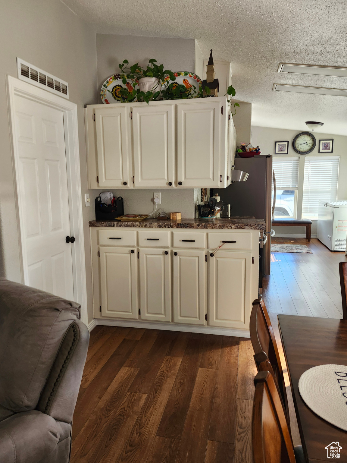 Kitchen featuring visible vents, dark wood finished floors, and white cabinetry