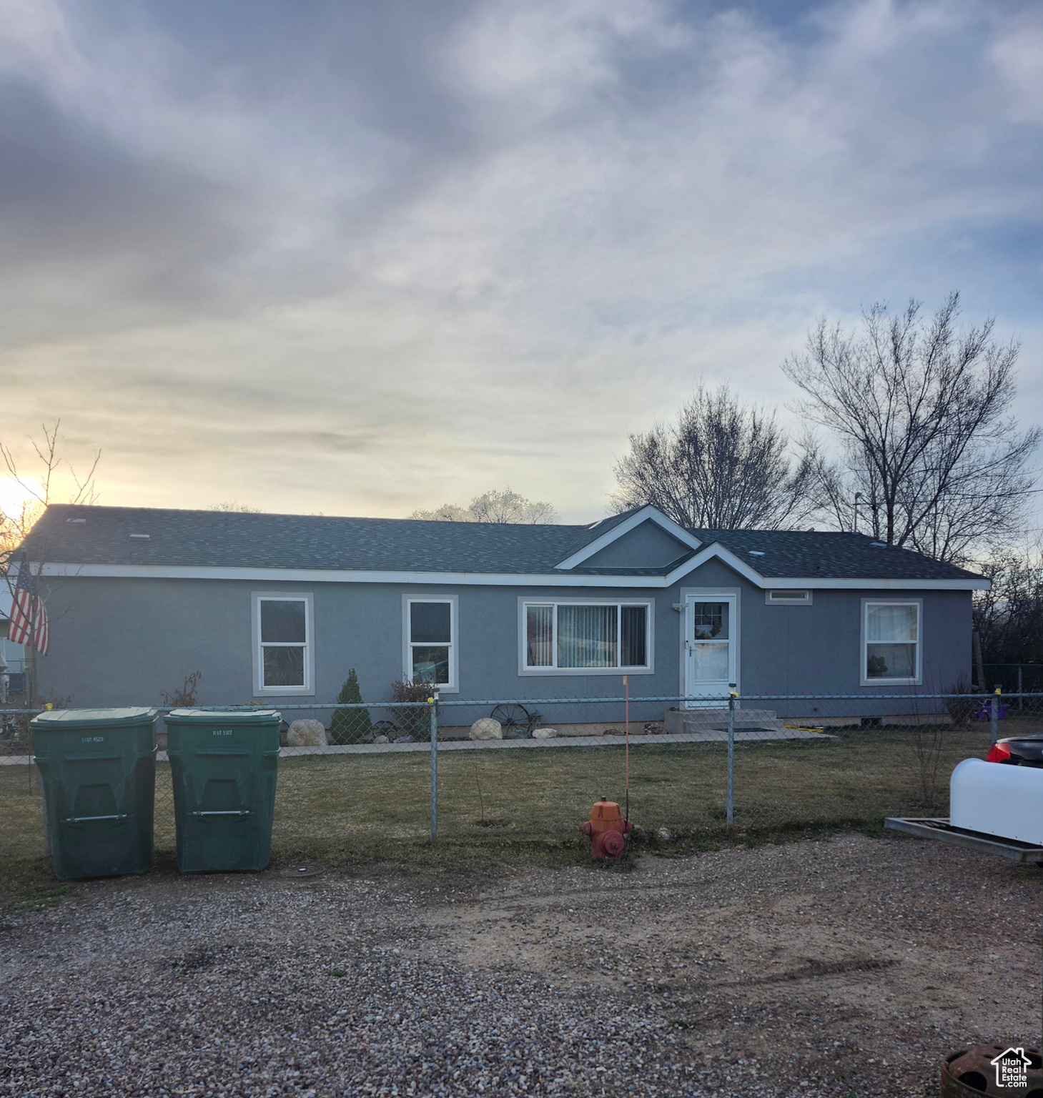 Ranch-style home featuring a front yard, a fenced front yard, and roof with shingles