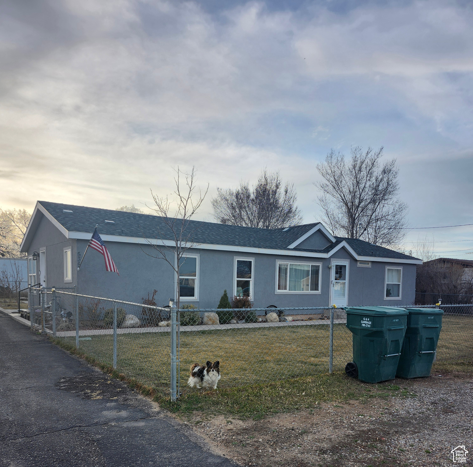 View of front of home featuring a fenced front yard, a front lawn, and roof with shingles