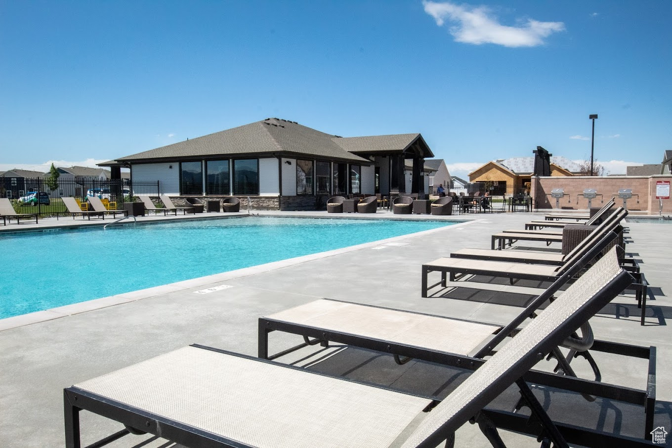 Community pool featuring a patio and fence