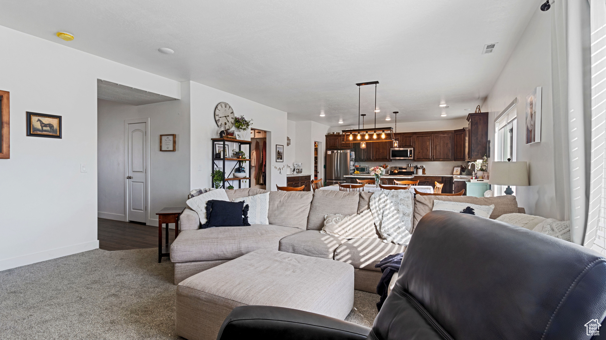 Living area with visible vents, carpet floors, and baseboards