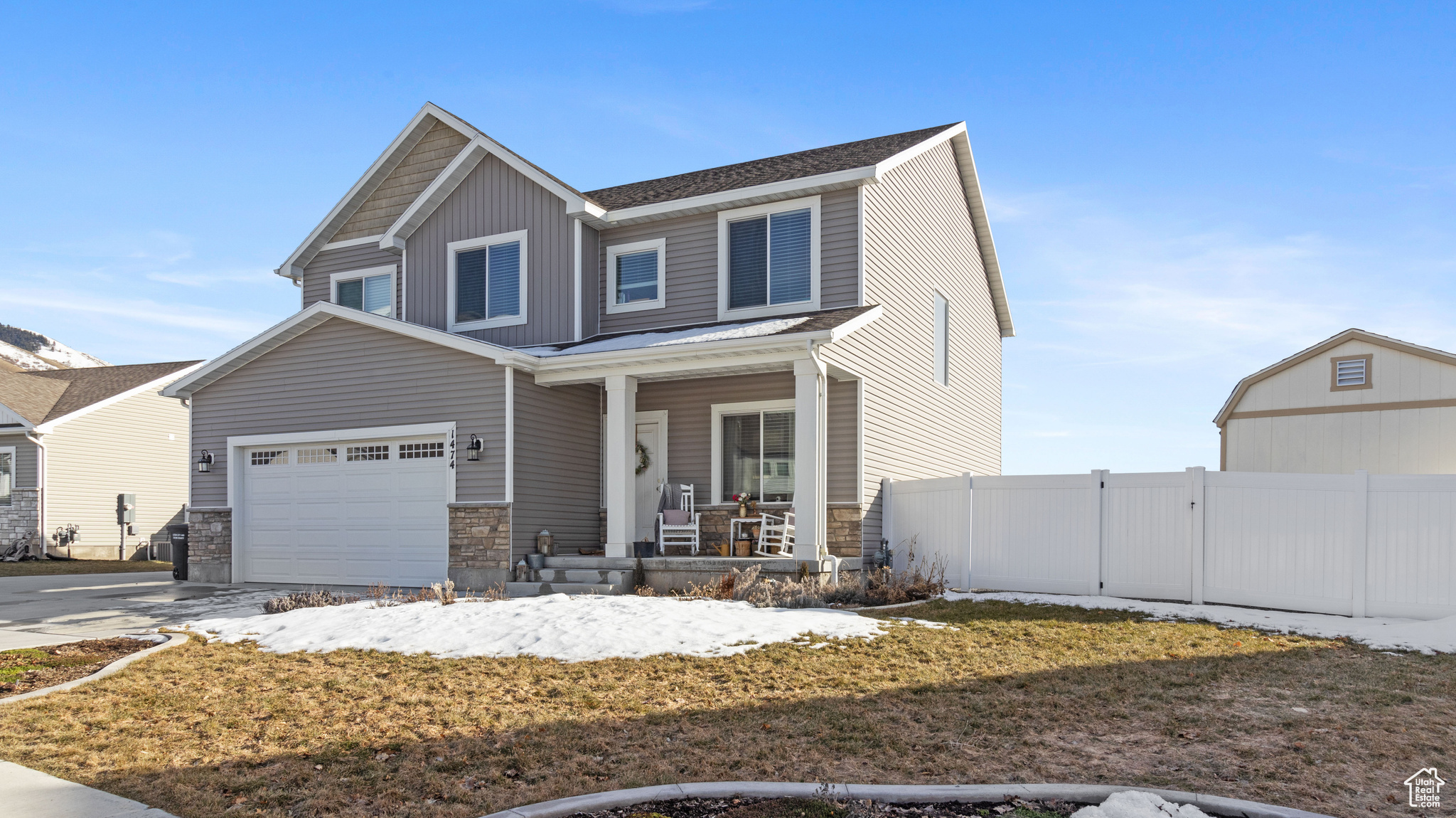 Craftsman-style house featuring driveway, a porch, fence, board and batten siding, and a garage