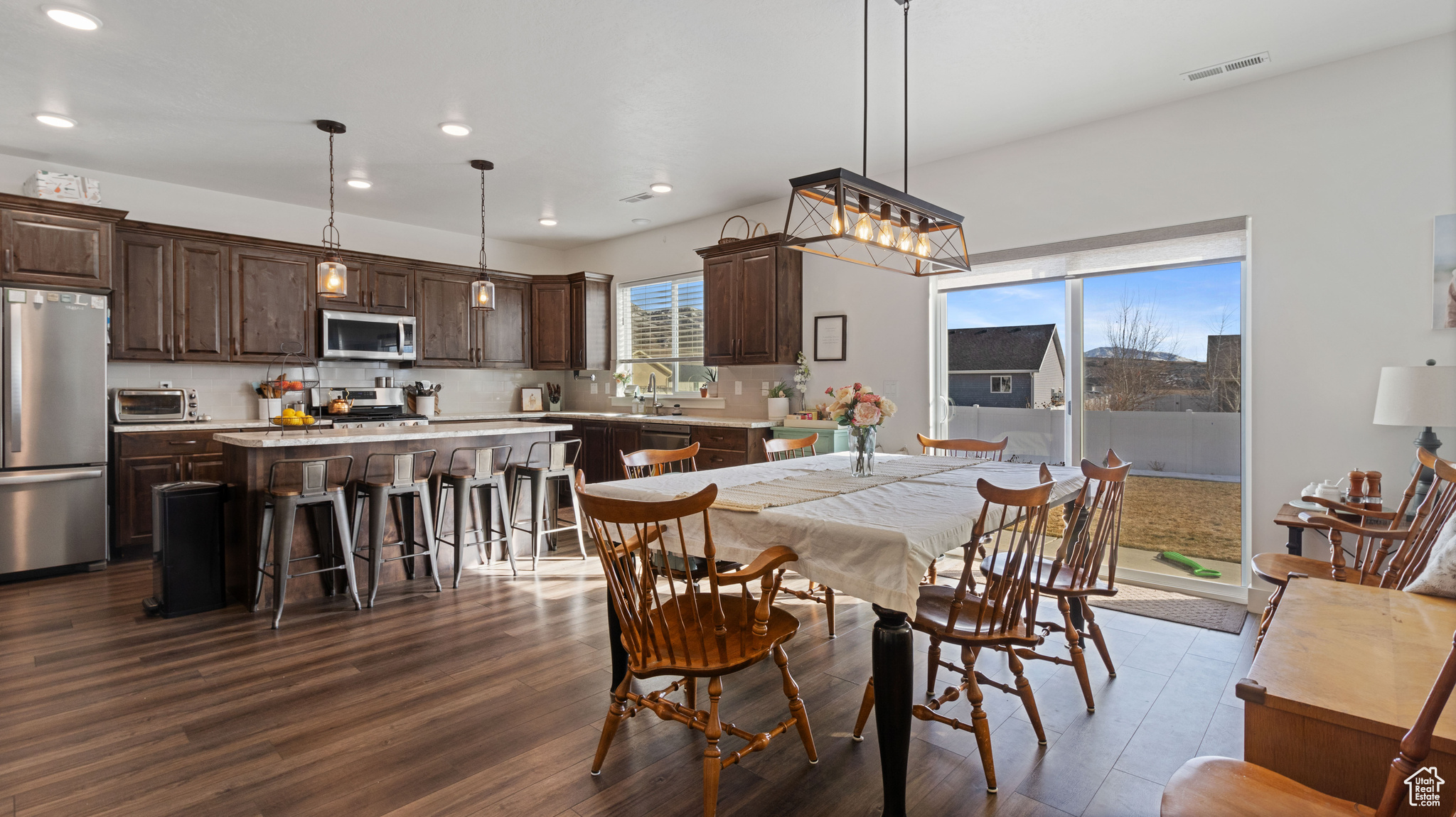 Dining space with dark wood finished floors, visible vents, recessed lighting, and a toaster